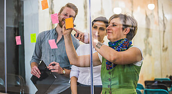 Meeting Post its Drei Azubis arbeiten zusammen mit Postits